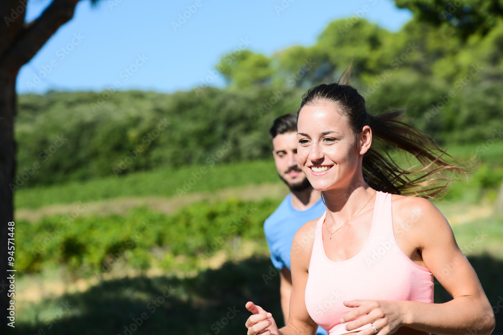 young healthy couple running outdoor in summer during a fitness exercise young healthy couple running outdoor in summer during a fitness exercise