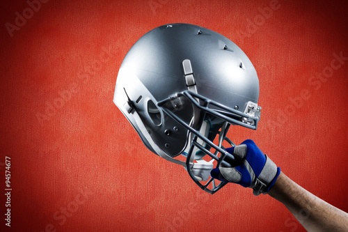 Composite image of cropped hand of sportsman holding helmet