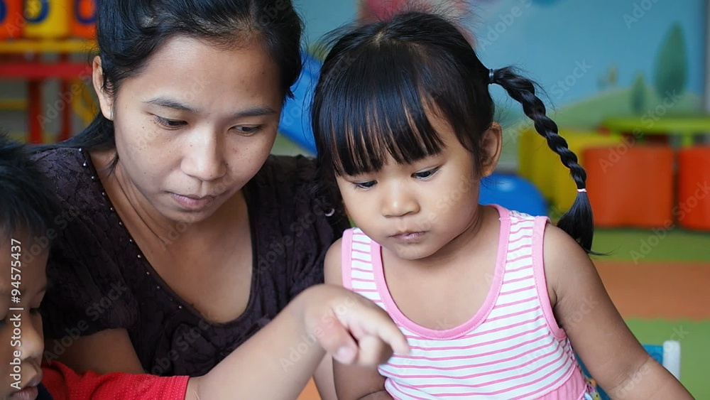 Happy family, Asian mother son and daughter reading together.
Happy family, Asian mother son and daughter reading together.