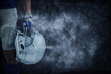 Composite image of american football player holding helmet