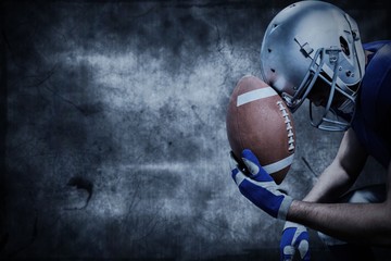 Composite image of american football player with ball against helmet