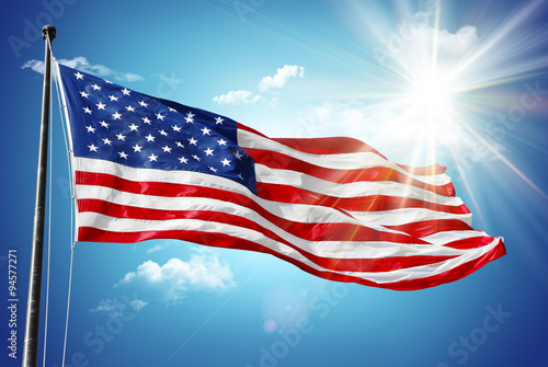 American flag in blue sky and sunshine background