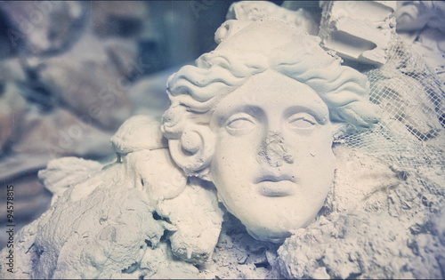 broken sculpture. plaster mask in the trash