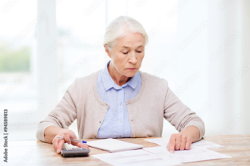 senior woman with papers and calculator at home senior woman with papers and calculator at home