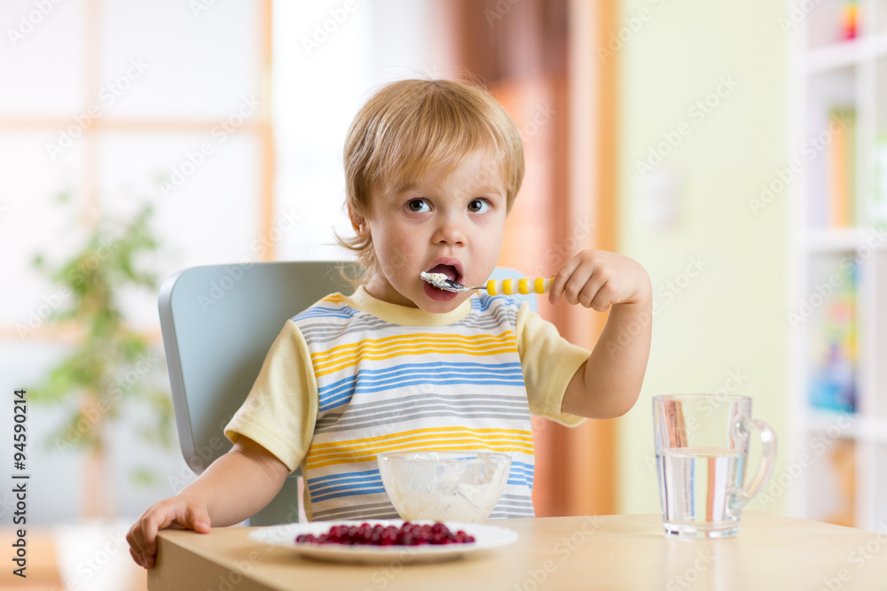 kid eating healthy vegetables at nursery room kid eating healthy vegetables at nursery room