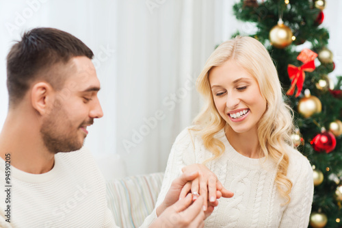 man giving woman engagement ring for christmas