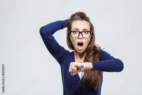 Woman holding hand with wrist watch and looking at camera