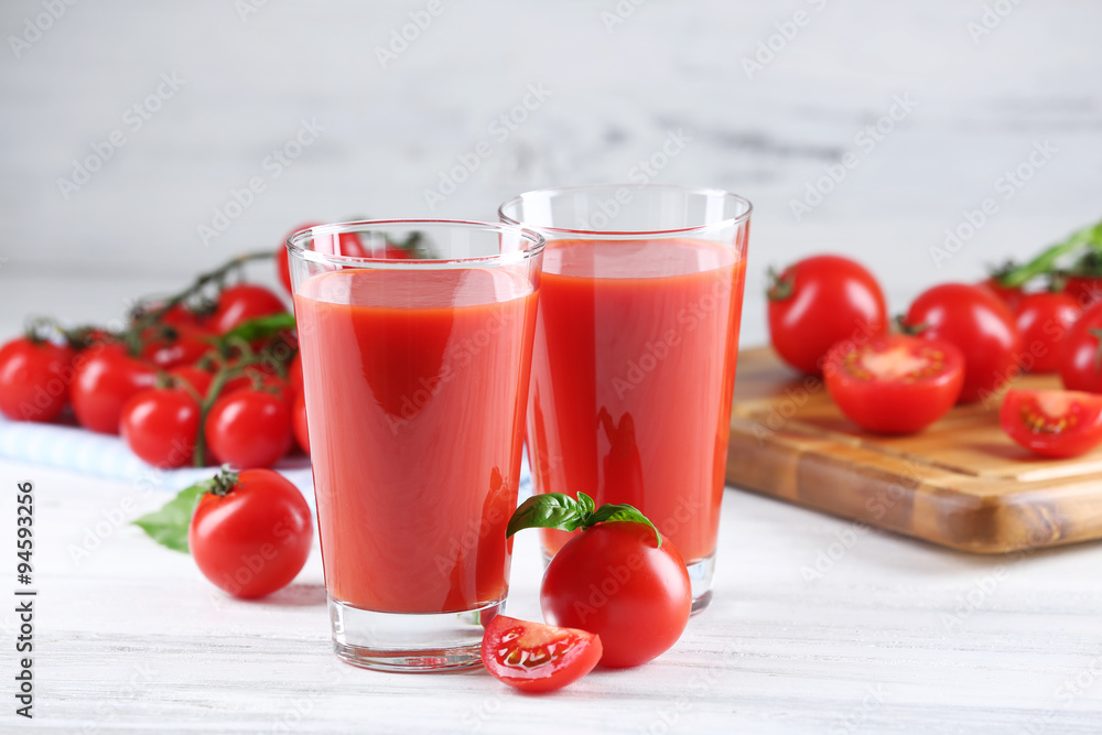 Glasses of tomato juice with vegetables on wooden table close up Glasses of tomato juice with vegetables on wooden table close up