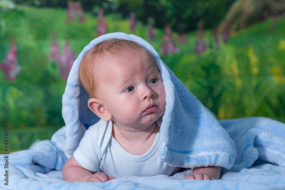 Portrait of a baby in a blue towel. Portrait of a baby in a blue towel.