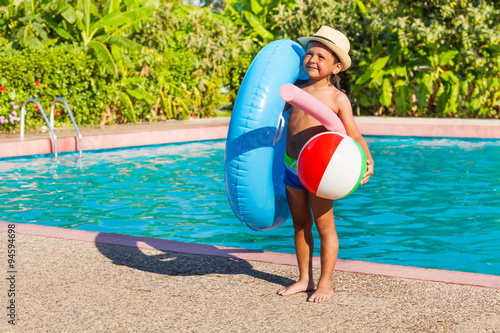 Bild auf Leinwand Small boy with inflatable ring, ball, pool noodle