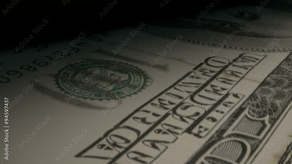 An extreme closeup of us 100 dollar banknotes flipping through in a counting machine An extreme closeup of us 100 dollar banknotes flipping through in a counting machine