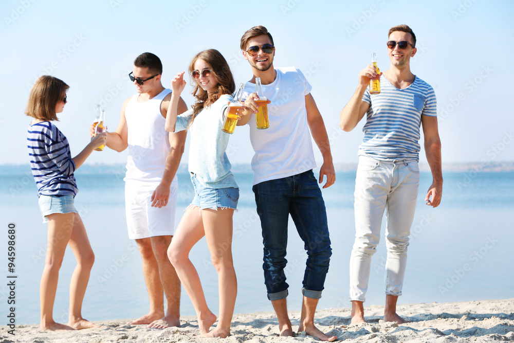 Obraz premium Young people with beer on the riverside