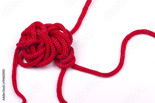 a tangle of matted red rope on a white background closeup