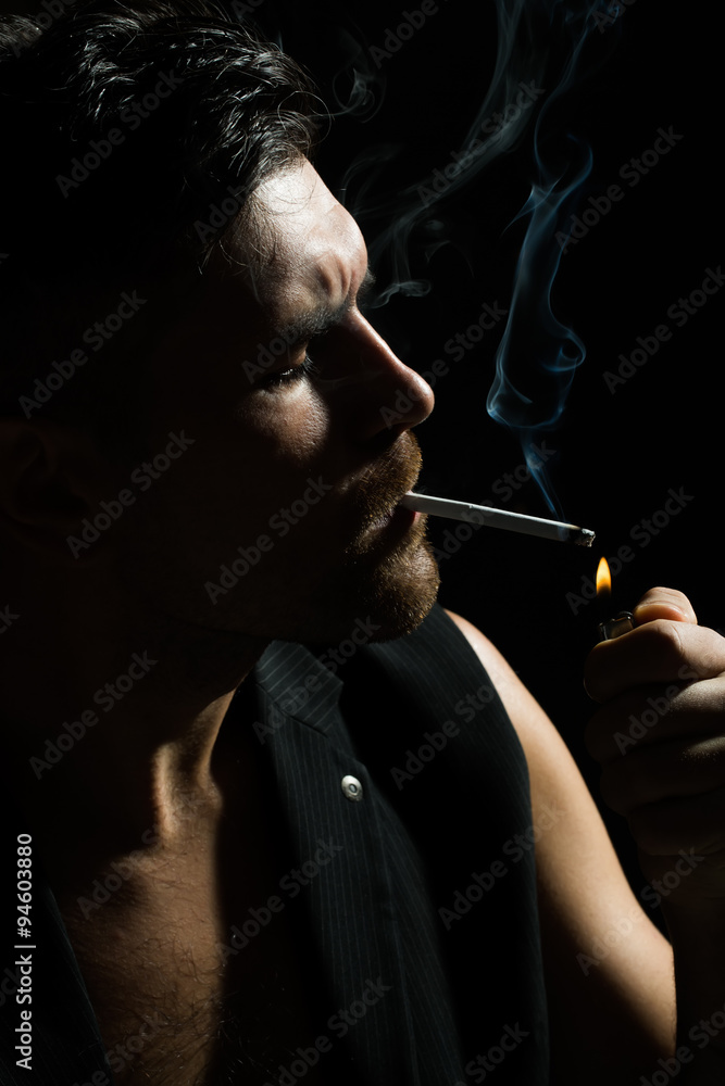 Fototapeta premium Bearded man lights up cigarette