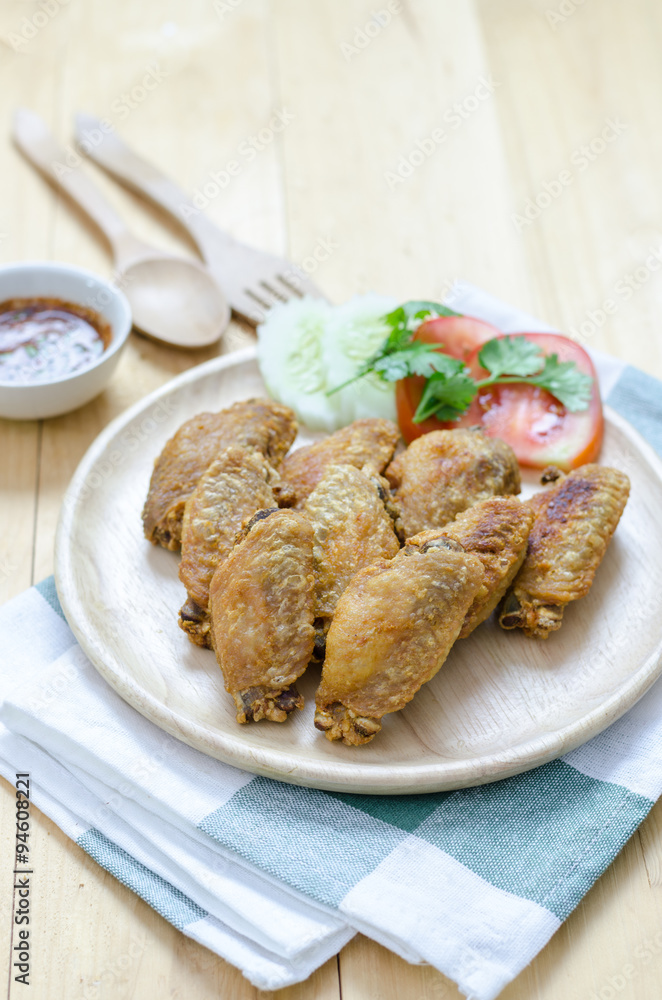 Fired chicken wings on wood plate with thai dip