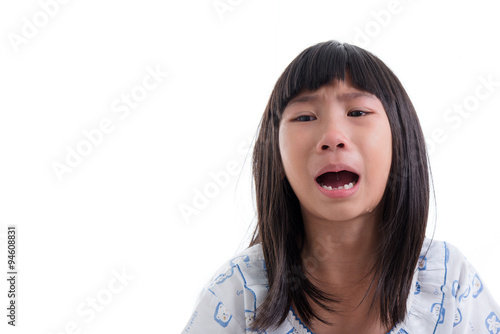 Close up Asian girl in pajamas crying on white.