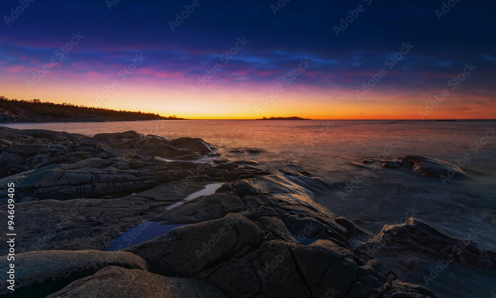Colorful sunrise at coastline with orange and blue dark dramatic