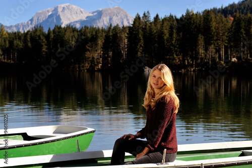 Junge Frau sitzt an einem Bergsee in einem Boot © C. Strom