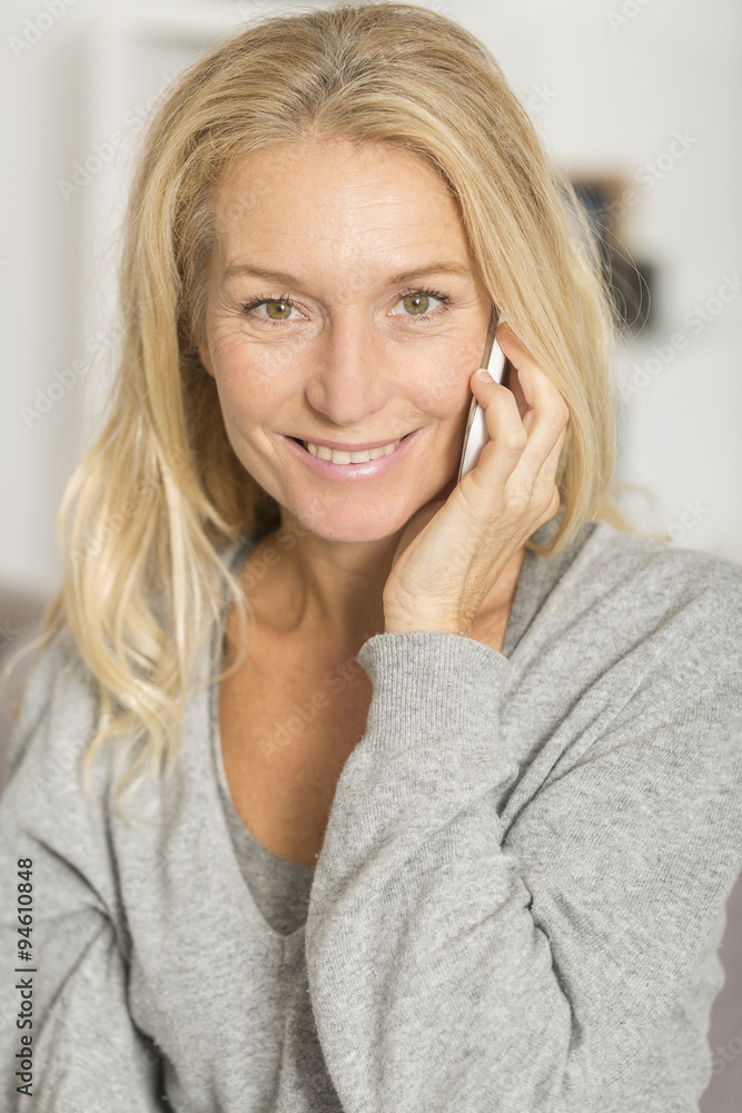 Mature woman at home using a mobil phone Mature woman at home using a mobil phone