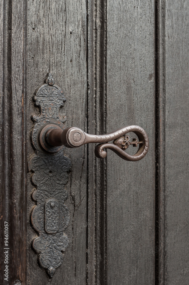Close up of old weathered door with iron handle Close up of old weathered door with iron handle