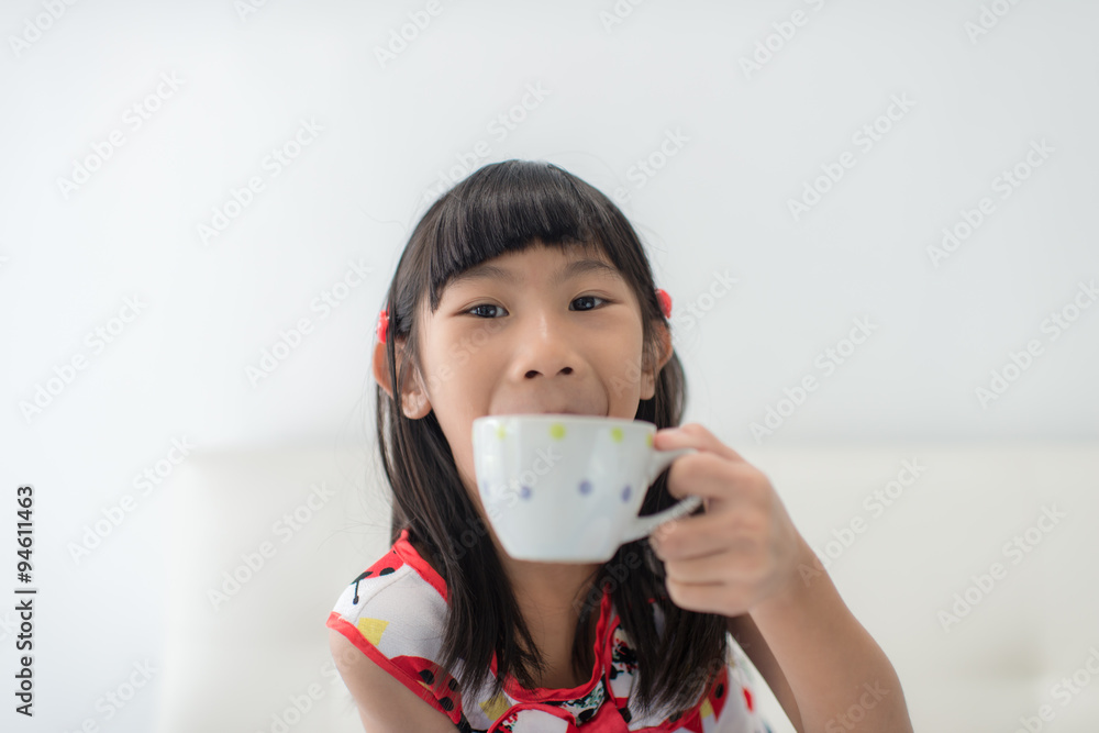 little girl drinking from a cup at home. little girl drinking from a cup at home.