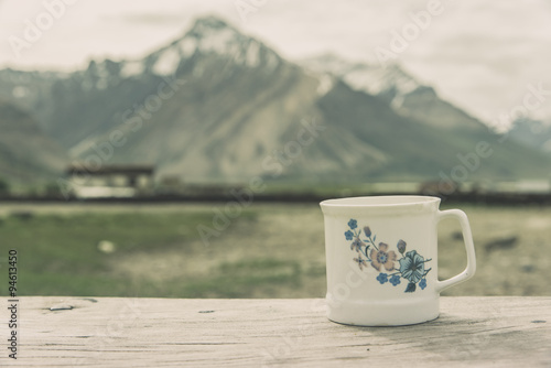 White coffee cup with snow mountain background.