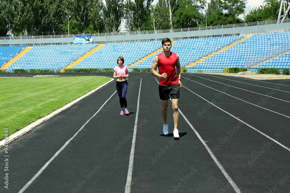 Fototapeta premium Young people jogging on stadium