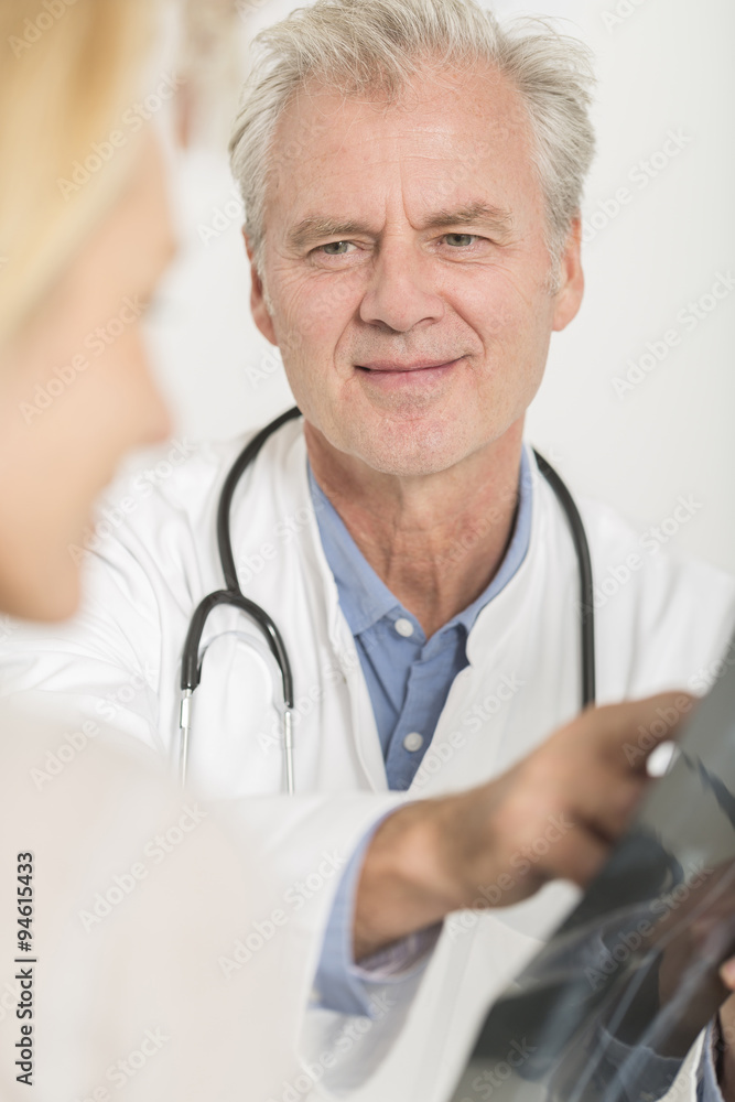 Doctor showing X-ray result to patient Doctor showing X-ray result to patient
