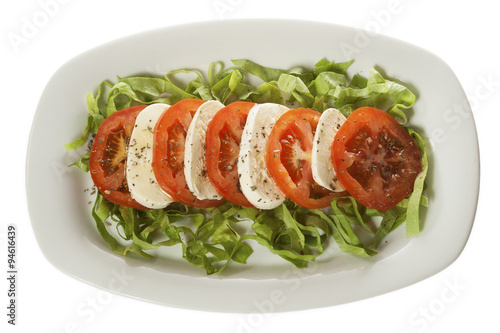 Italian salad - Caprese salad, tomato and mozzarella with spices, served on a white plate. Isolated on white.