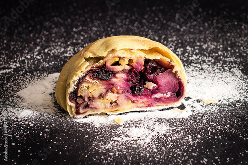 Photography Slice of fresh baked homemade apple strudel with berries and sugar powder, isola