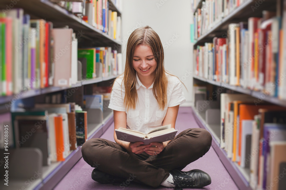 girl reading in the library, smiling happy student girl reading in the library, smiling happy student