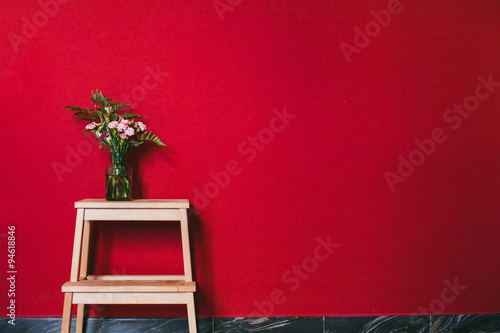 simple design of interior, flowers in vase on red wall background