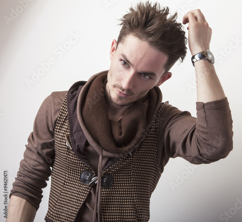 Attractive young man in a brown sweater pose in studio.
 photo