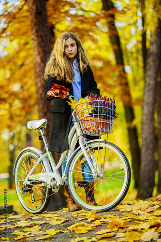 Biking, Young and beautiful girl with bike in autumn park