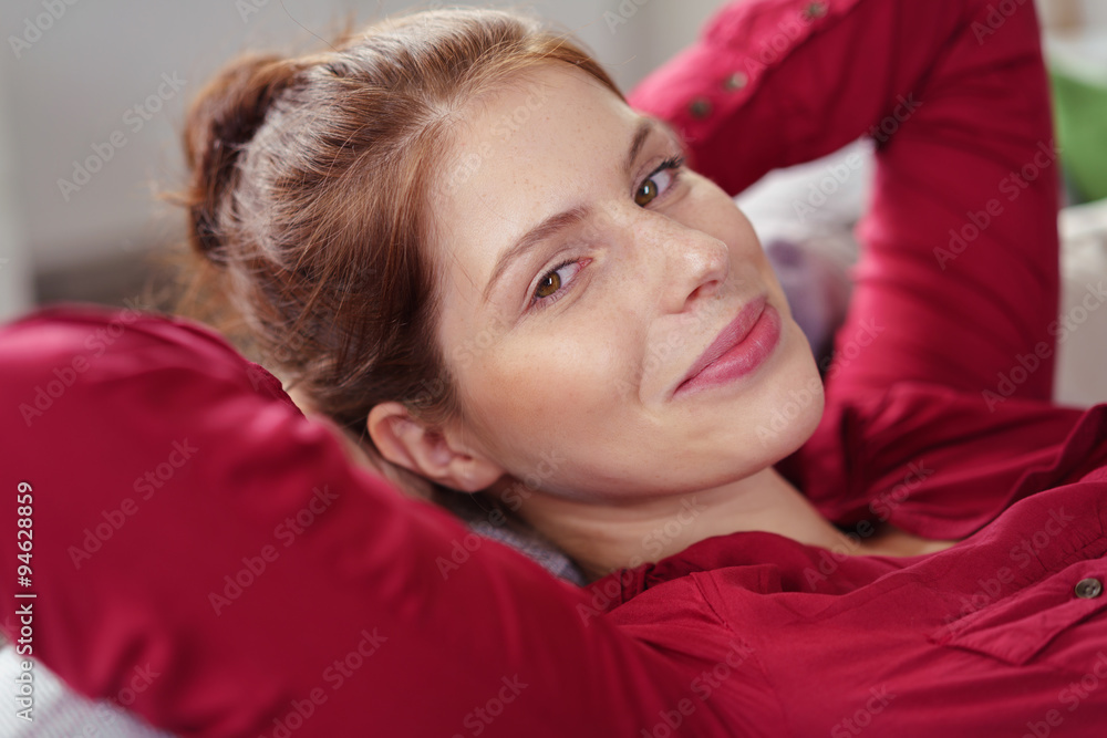 Fototapeta premium schöne lächelnde frau liegt entspannt auf dem sofa