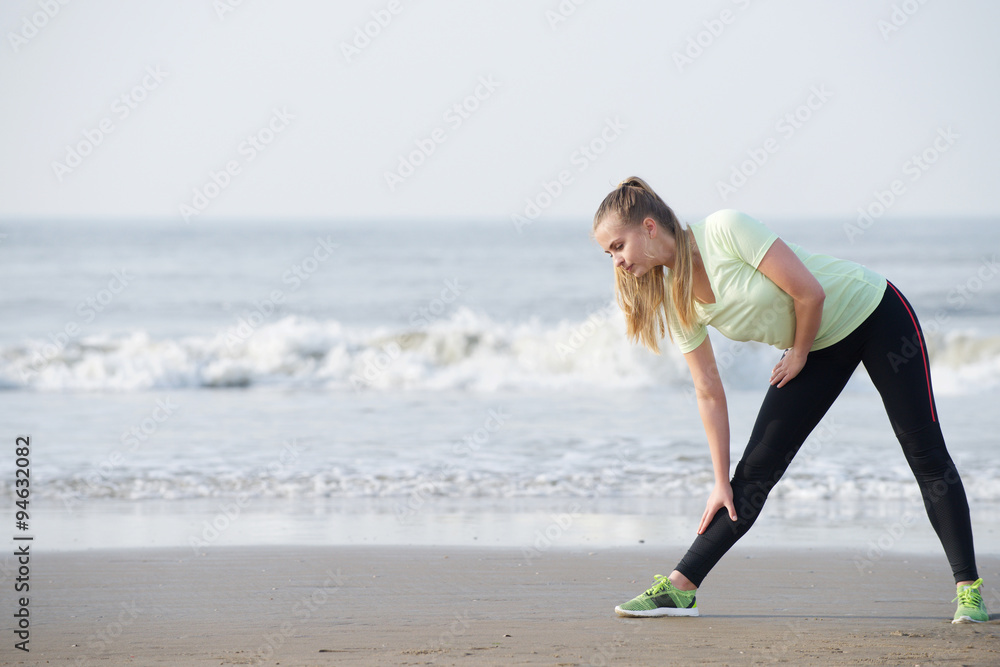Sporty young woman bend down stretching at the beach Sporty young woman bend down stretching at the beach
