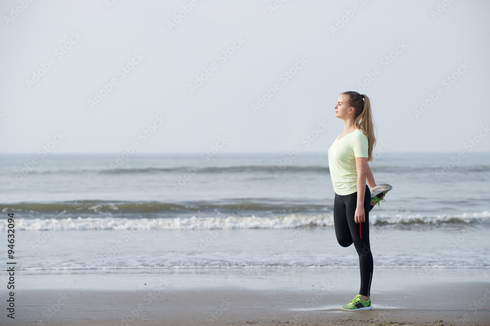 Sporty young woman stretching exercise at the beach Sporty young woman stretching exercise at the beach