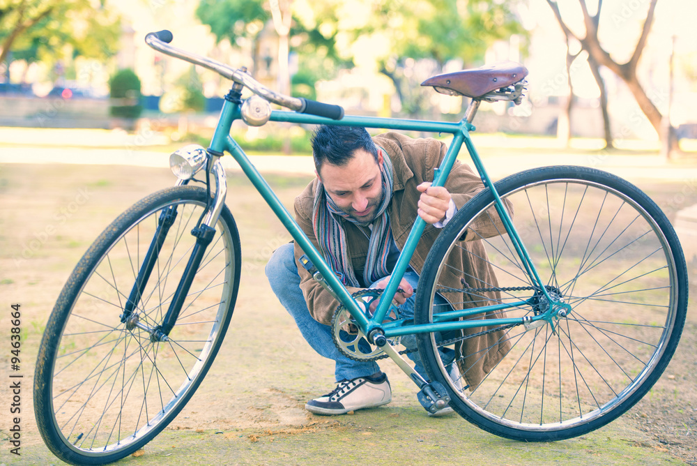 Fototapeta premium Man checking the chain an antique bicycle