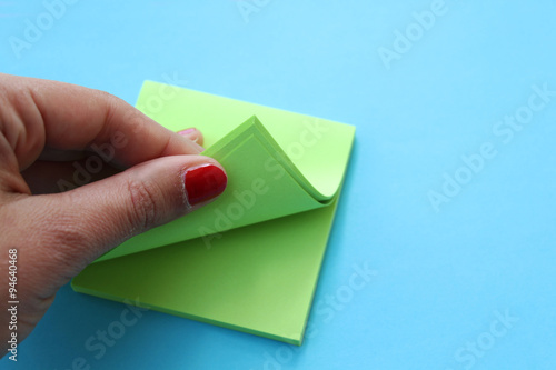 Female's hand opening stick notes paper - looking for important date concept