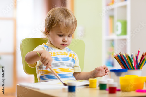 Little boy painting on crea...