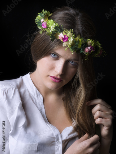 Portrait of a young woman with blue eyes wearing a flower diadem