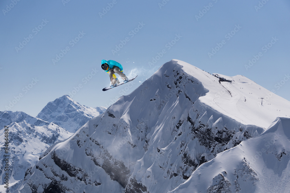 Flying snowboarder on mountains