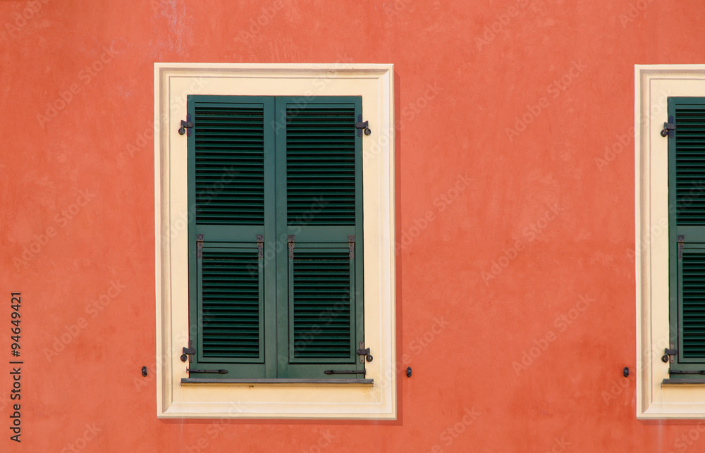 decorative wooden window shutters closed on the exterior wall