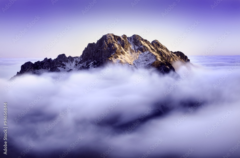 Obraz premium Early morning in a Low Fatra, In the middle of picture is hill and around it is a fog. Natural background with blue colour