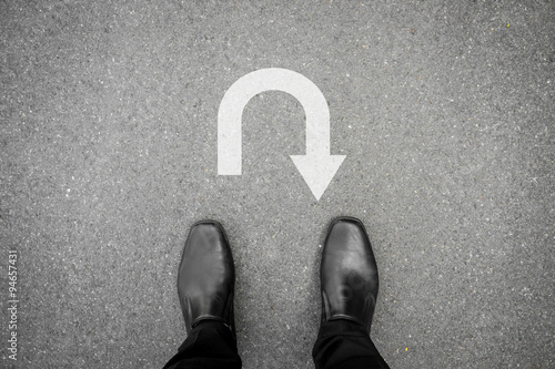 Bild auf Leinwand Black shoes standing in front of u turn symbol