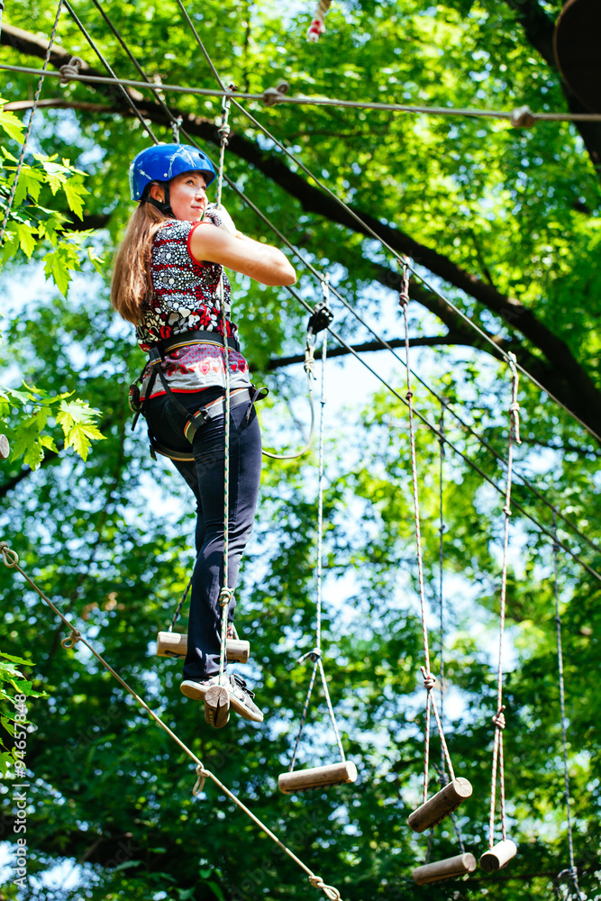 Obraz premium Adventure climbing high wire park - woman on course in mountain