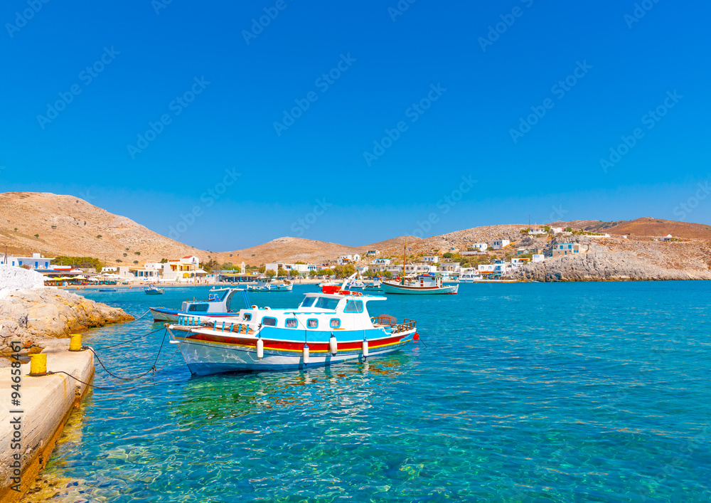 traditional fishing boats docked in the port of Pserimos island in Greece