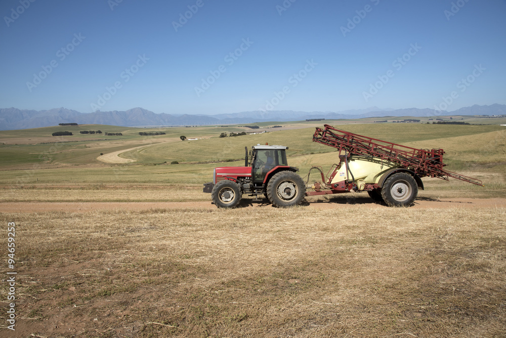 Obraz premium Farm tractor and crop sprayer in the Swartland region of South Africa