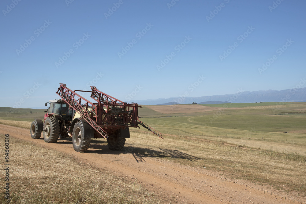 Fototapeta premium Farm tractor and crop sprayer in the Swartland region of South Africa
