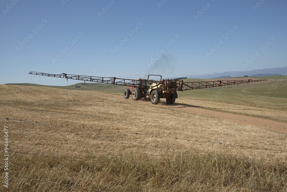 Obraz premium Farm tractor and crop sprayer in the Swartland region of South Africa